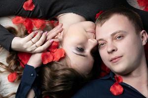 amorevole coppia. uomo e donna nel rosa petali. bellissimo giovane marito e moglie. foto