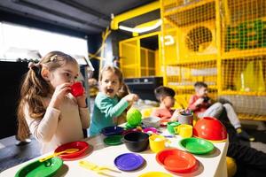 Due sorelle giocando nel bambini cucina a bambini giocare centro. foto