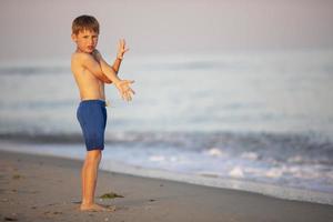 bambino a mare. un' ragazzo giochi su il costa. foto