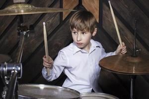 il bambino giochi il batteria. ragazzo musicista dietro a un' tamburo kit. foto