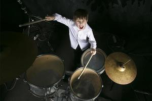 il bambino giochi il batteria. ragazzo musicista dietro a un' tamburo kit. foto
