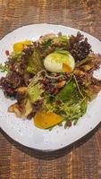 dieta insalata di fresco verdure. lattuga, in camicia uovo, pomodori, verde cipolle e chili peperoni. salsa. foto