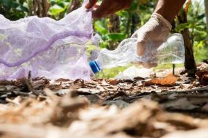 persone mettere plastica bottiglie nel spazzatura borse. agricoltura e clima modificare, micro plastica sciupare. cibo e plastica confezione industria foto