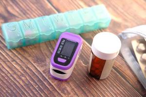 pulsossimetro e contenitore della pillola sul tavolo