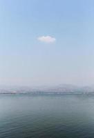 chiaro cielo su il lago con bellissimo nuvole. verticale foto