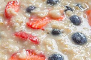 vicino su di fiocchi d'avena porridge con fragole e mirtilli foto