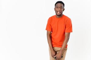 africano tipo nel un arancia maglietta con un' mobile Telefono e nel i pantaloni foto