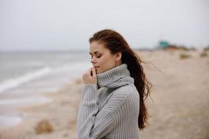 allegro donna nel un' maglione volante capelli di il oceano turismo stile di vita foto