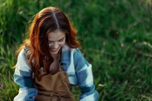 donna dire bugie su il erba sorridente giocando e coccole sua cane nel natura nel il parco nel il estate tramonto. il concetto di Salute e amore di animali, trattamento di zecche e pulci erba e animali foto