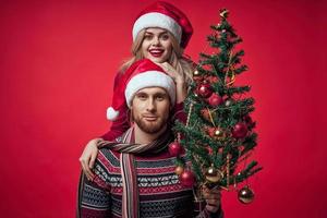 uomo e donna Natale albero decorazione divertimento vacanza rosso sfondo foto