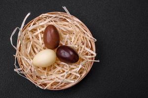 cioccolato Pasqua gallina e uova nel un' nido con cannuccia foto