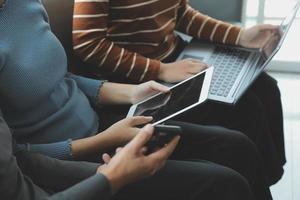 bellissimo donna seduta su un' all'aperto e utilizzando a il computer portatile. donna e amico avendo divertimento con nuovo tecnologia e shopping in linea a all'aperto posto. foto