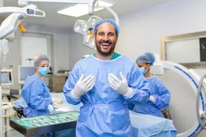 ritratto di maschio chirurgo in piedi nel operativo camera, pronto per opera su un' paziente. maschio medico lavoratore chirurgico uniforme nel operazione Teatro. foto