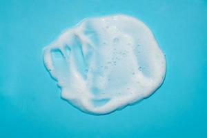 bianca schiuma schiuma idratante detersivo su blu foto