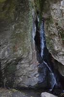 minuscolo alto cascata fra grande rocce foto