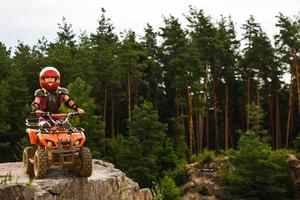 ragazza equitazione quadrilatero bicicletta montagna, atv. carino bambino su quadriciclo. bambini estate vacanza attività. foto