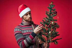 emotivo uomo nel un' Santa cappello Natale decorazioni vacanza nuovo anno rosso sfondo foto