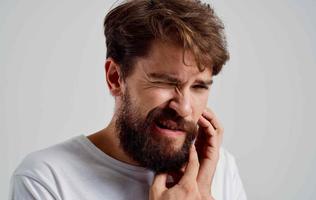 barbuto uomo Tenere il suo viso mal di denti foto