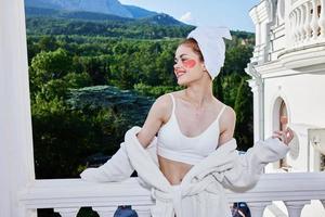 un' in forma ragazza sta su il balcone di il Hotel Perfetto soleggiato mattina foto