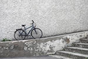 singolo bicicletta Appoggiato contro pietra parete, vero paesaggio urbano foto