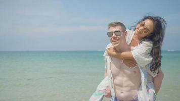 un' coppia abbracci e baci su il spiaggia su loro estate vacanza e essi Sorridi e siamo contento su vacanza. foto