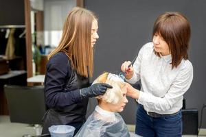 Due parrucchieri tintura capelli di donna foto