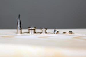 set di accessori per piercing su una tavola di legno foto