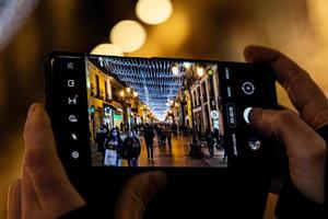bellissimo originale Natale illuminazione a notte nel il spagnolo città di saragozza foto nel smartphone