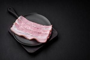 delizioso fresco Bacon strisce con spezie e sale foto