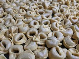 un' vicino su superiore Visualizza tiro di crudo tortellini con bianca funghi struttura cibo fotografia foto