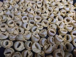 un' vicino su superiore Visualizza tiro di crudo tortellini con bianca funghi struttura cibo fotografia foto