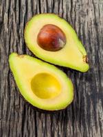 avocado dimezzato con nucleo isolato su uno sfondo di legno foto