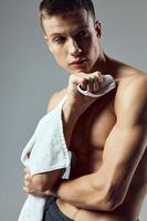 sportivo uomo asciugamani nel mani pompato su braccia fitness allenarsi foto