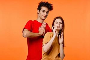 tipo e ragazza nel colorato magliette divertimento studio arancia sfondo foto