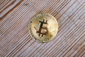 primo piano di una moneta di criptovaluta bitcoin su uno sfondo di legno foto