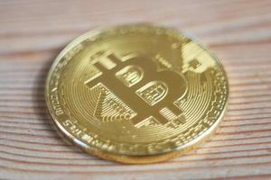 bitcoin su uno sfondo di superficie in legno. criptovaluta bitcoin. metallo dorato bitcoin crypto concetto di valuta foto