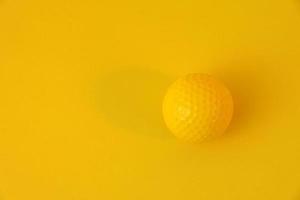 pallina da golf giallo isolato su sfondo giallo. concetto monotono. copia spazio pulito. foto