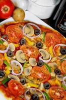 popolare colorato ingredienti come piace pomodori, formaggio, fungo, capsico, olive e altro ingredienti al forno salutare Pizza. foto