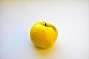 mela verde gialla su sfondo bianco da vicino foto