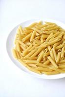primo piano giallo della pasta deliziosa su un piatto bianco foto