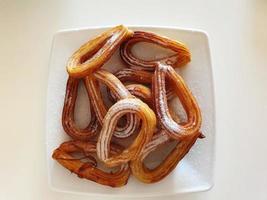 gustoso, croccante spagnolo churros con zucchero e cannella su un' bianca piatto foto