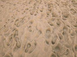 vicino su spiaggia struttura impronte su sabbia foto