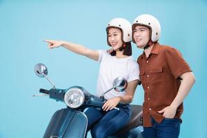 giovane asiatico coppia cavalcata scooter su sfondo foto