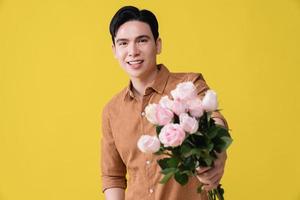 giovane asiatico uomo Tenere fiore su sfondo foto