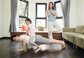 giovane asiatico famiglia esercizio a casa foto