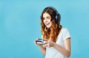allegro donna nel un' bianca maglietta con un' telecomando da gioco nel sua mani video Giochi divertimento foto