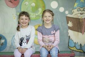 Due divertente ragazze a partire dal scuola materna su un' estate camminare. sei anno vecchio bambini giocare su il terreno di gioco. foto