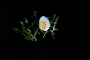 Pasqua carta con uovo su un' nero sfondo e verde le foglie foto