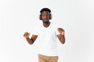 uomo africano aspetto nel bianca maglietta con cuffie musica moderno stile tecnologia foto