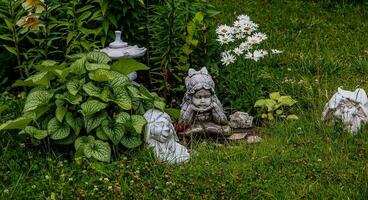 verde giardino con fiori e gesso figurina naturale sfondo foto